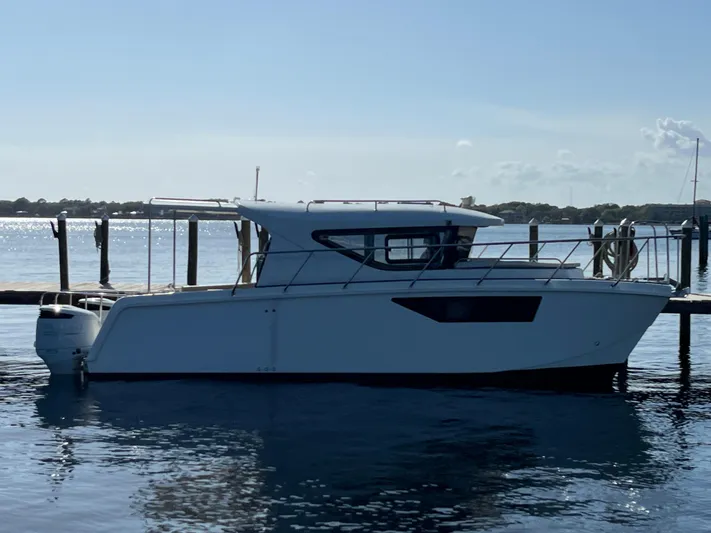  Yacht Photos Pics 2024 Tuna catamaran docked on calm water under clear sky.