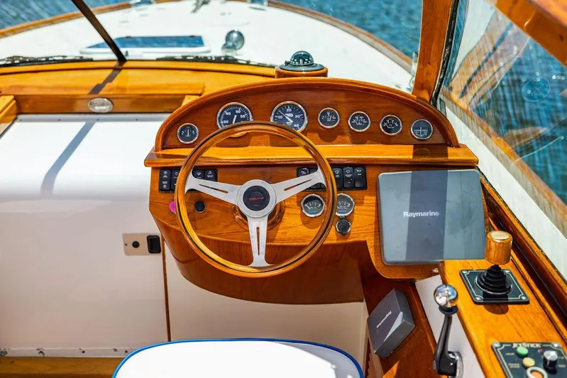  Yacht Photos Pics 2004 Hinckley Talaria 29 R boat dashboard with wooden steering wheel and navigation instruments.