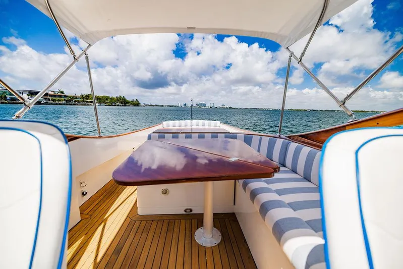  Yacht Photos Pics 2004 Hinckley Talaria 29 R boat interior with striped seating and wooden table, ocean view.