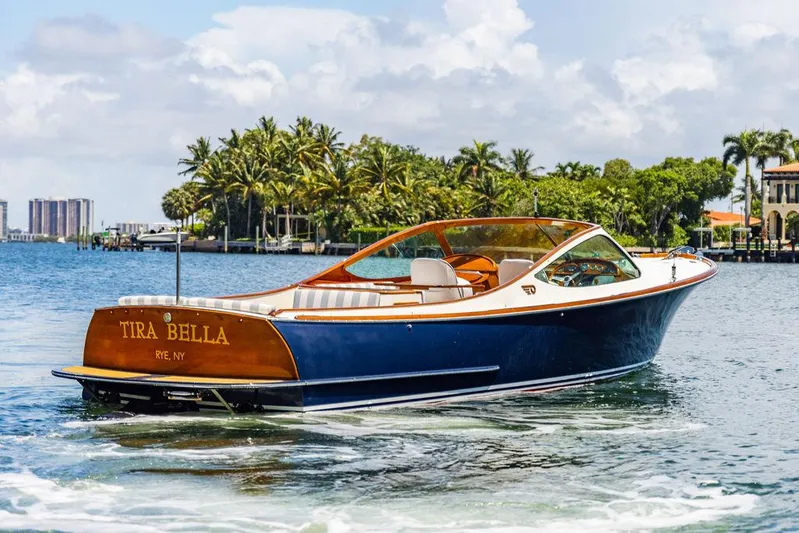  Yacht Photos Pics 2004 Hinckley Talaria 29 R boat cruising on a sunny day near palm trees.