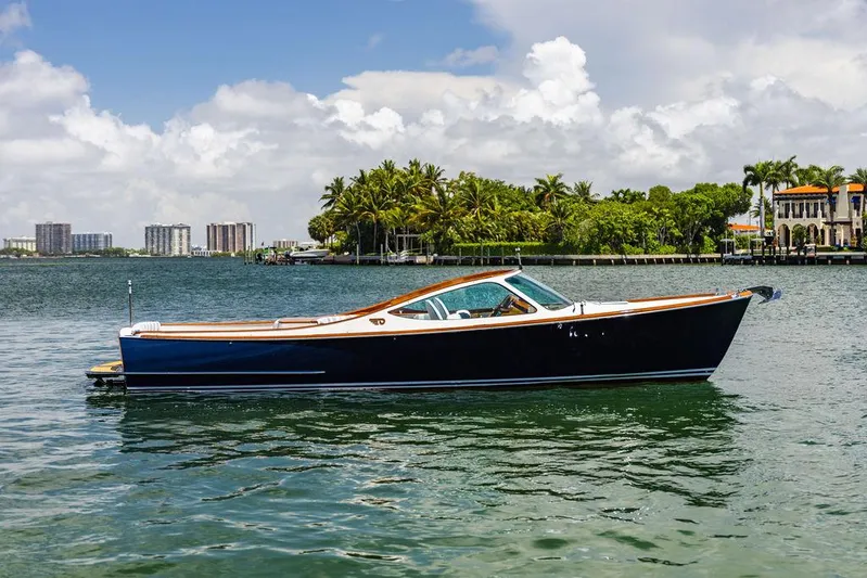  Yacht Photos Pics 2004 Hinckley Talaria 29 R boat on calm water with palm trees in the background.