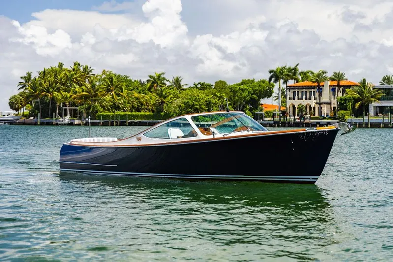  Yacht Photos Pics 2004 Hinckley Talaria 29 R boat on scenic waterfront with palm trees and luxury homes.