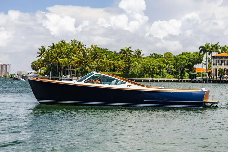  Yacht Photos Pics 2004 Hinckley Talaria 29 R boat cruising on a scenic waterway with palm trees.