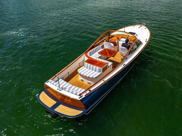  Yacht Photos Pics 2004 Hinckley Talaria 29 R boat on water, featuring elegant design and striped seating.