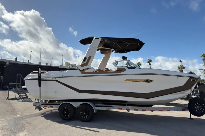  Yacht Photos Pics 2025 Nautique Super Air Nautique G25 Paragon boat on trailer under blue sky.