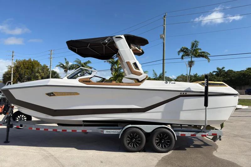  Yacht Photos Pics 2025 Nautique Super Air Nautique G25 Paragon boat on trailer, sunny day, palm trees.