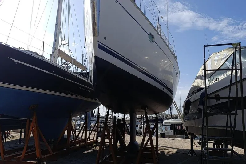  Yacht Photos Pics 2004 Jeanneau Sun Odyssey 43 sailboat in dry dock, surrounded by other vessels.