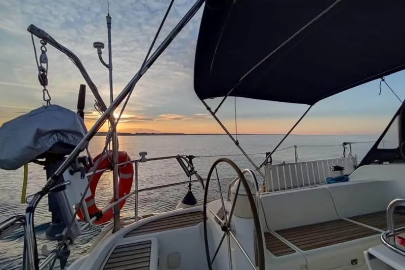  Yacht Photos Pics 2004 Jeanneau Sun Odyssey 43 sailboat at sunset, featuring a spacious cockpit and ocean view.