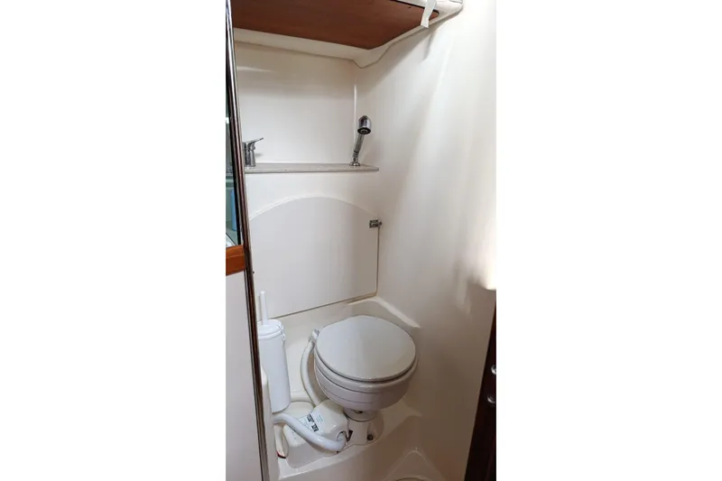 Yacht Photos Pics Compact bathroom in 2004 Jeanneau Sun Odyssey 43 sailboat, featuring toilet and sink.
