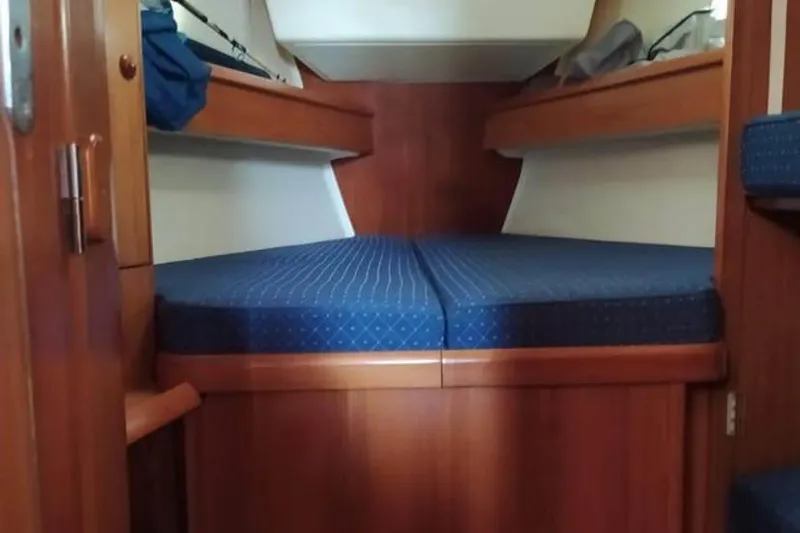  Yacht Photos Pics Interior cabin of 2004 Jeanneau Sun Odyssey 43 sailboat with blue cushioned bed.