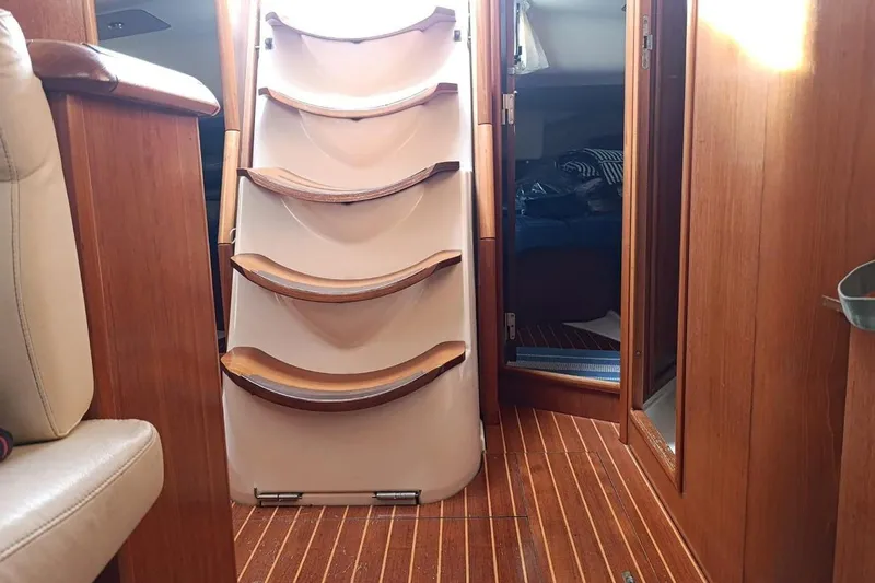  Yacht Photos Pics Interior of 2004 Jeanneau Sun Odyssey 43 sailboat with wooden steps and cabin view.