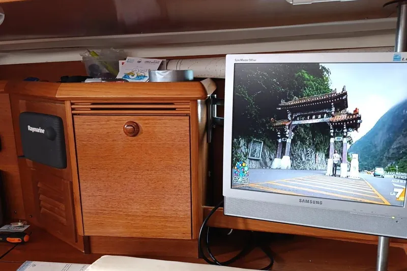  Yacht Photos Pics Interior of 2004 Jeanneau Sun Odyssey 43 with wooden cabinetry and Samsung monitor displaying scenic image.
