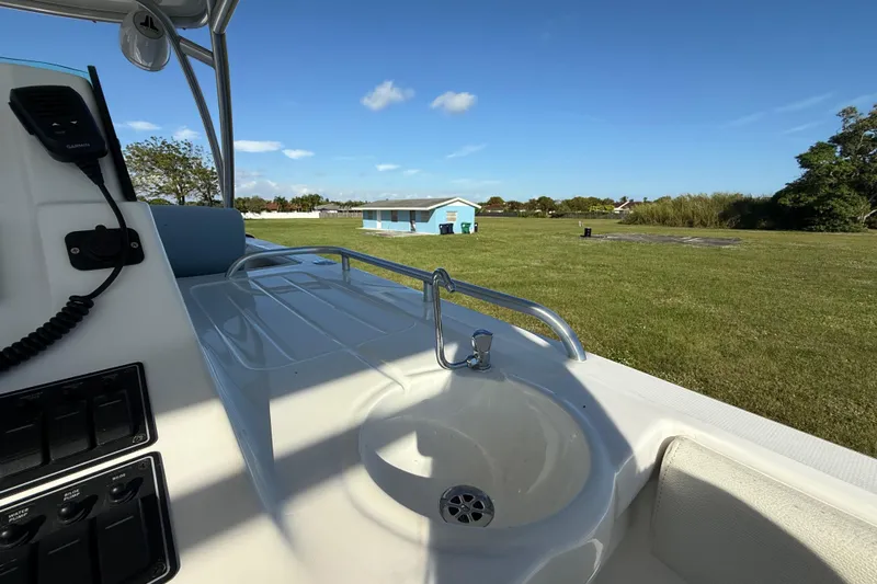  Yacht Photos Pics 2016 Extreme Boats 38 Cuddy Cabin interior with sink and control panel, grassy landscape view.