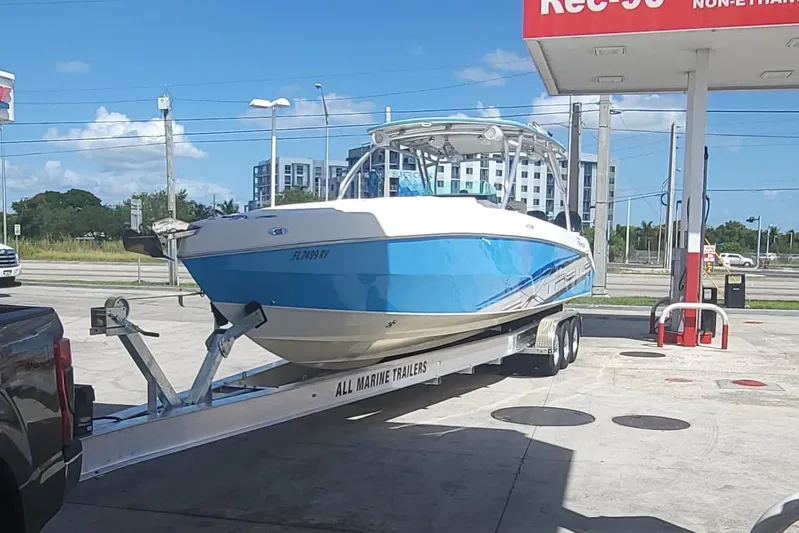  Yacht Photos Pics 2016 Extreme Boats model on trailer at gas station under clear blue sky.