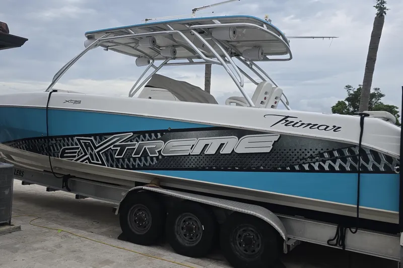  Yacht Photos Pics 2016 Extreme Boats Trimar on trailer, blue and white design, parked outdoors.