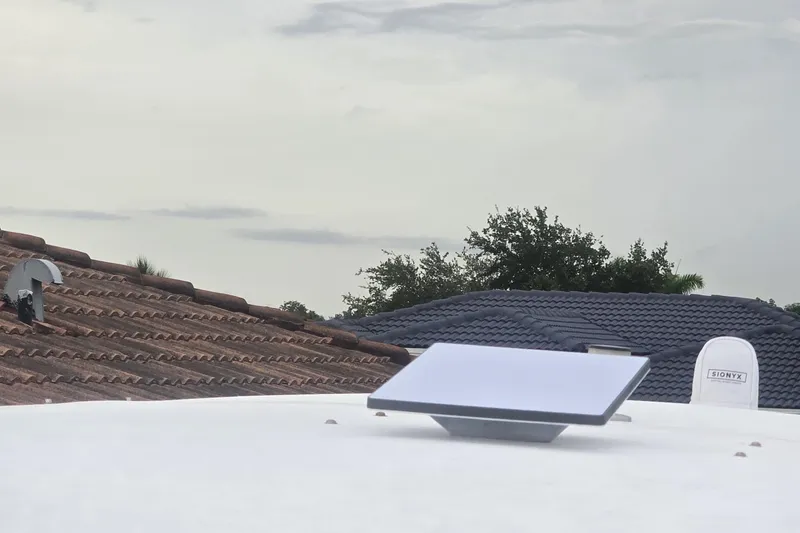  Yacht Photos Pics Rooftop with solar panel and vent, cloudy sky background.