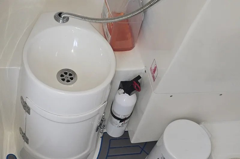  Yacht Photos Pics Compact boat bathroom with sink, fire extinguisher, and storage on a 2016 Extreme Boats model.