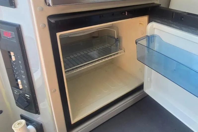  Yacht Photos Pics Open fridge inside a 2016 Extreme Boats model, showcasing interior shelving.