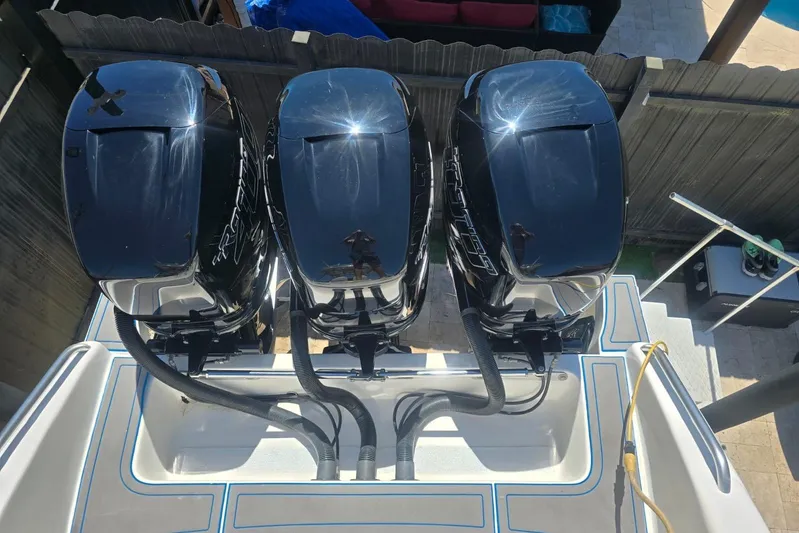  Yacht Photos Pics Triple outboard motors on a 2016 Extreme Boats vessel, viewed from above.