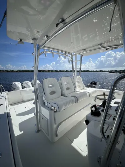  Yacht Photos Pics 2021 Contender 44ST boat interior with white seating and steering wheel, overlooking a serene water view.