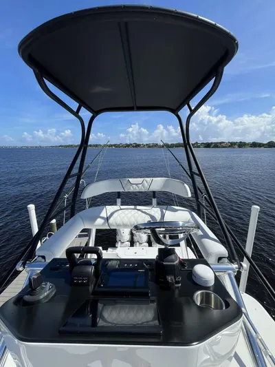  Yacht Photos Pics 2021 Contender 44ST boat helm with canopy on calm water.