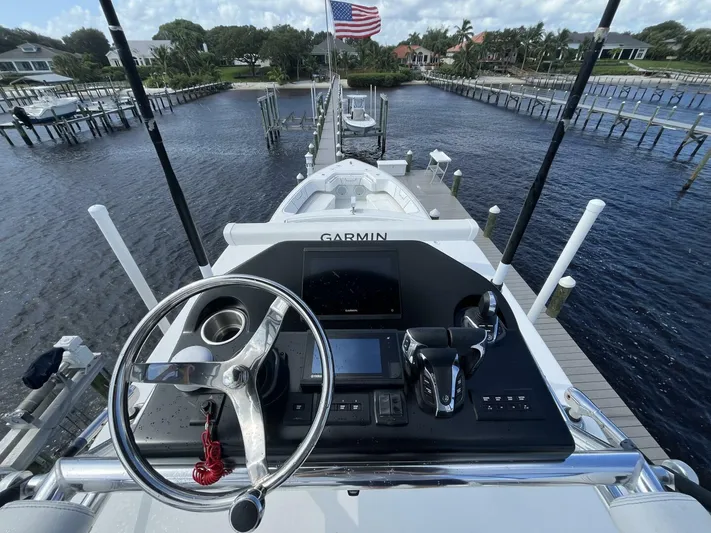  Yacht Photos Pics 2021 Contender 44ST boat helm with Garmin navigation, docked by waterfront homes.