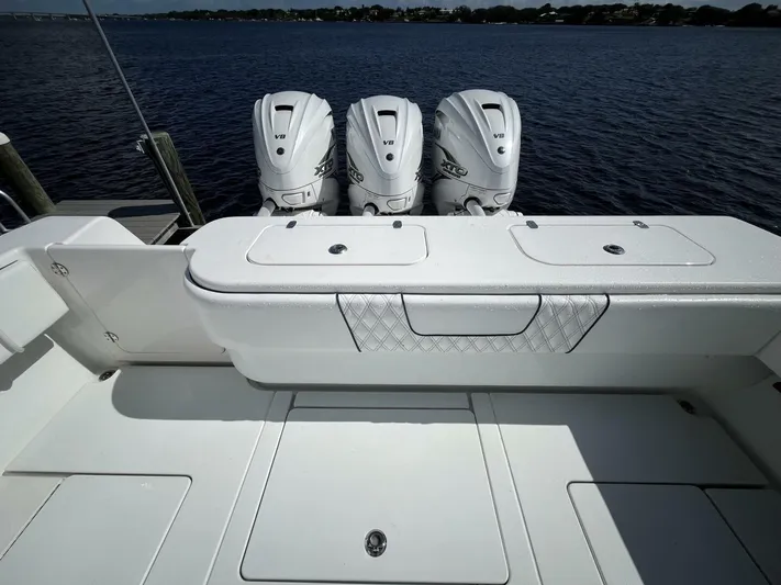  Yacht Photos Pics 2021 Contender 44ST boat with triple outboard engines on a calm water backdrop.