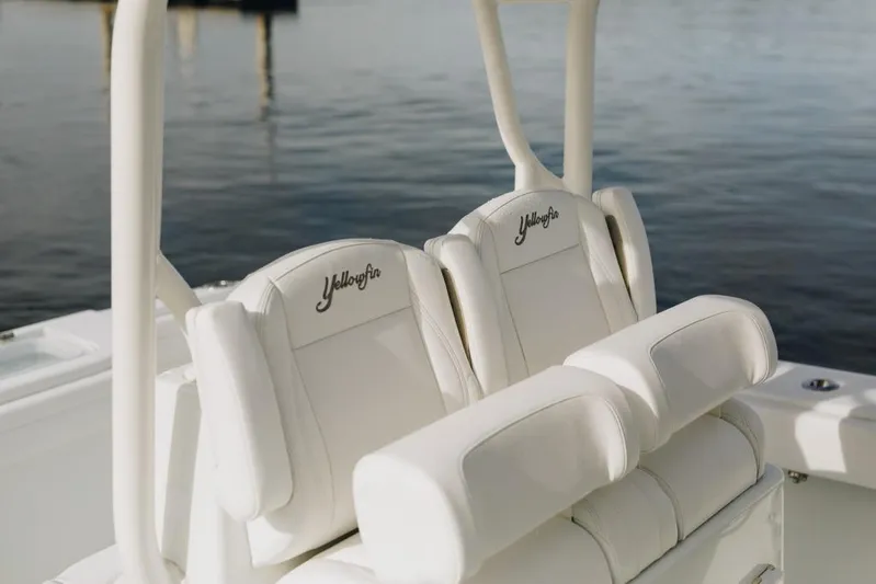 Lunasea Yacht Photos Pics 2023 Yellowfin 32 Offshore boat seats with embroidered logo, on calm water.