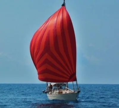 Windragon Yacht Photos Pics Sailboat with red spinnaker on open sea, Island Packet 37, 1995 model.