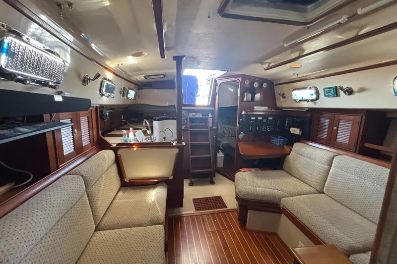 Windragon Yacht Photos Pics Interior of a 1995 Island Packet 37 sailboat, featuring cozy seating and wooden finishes.