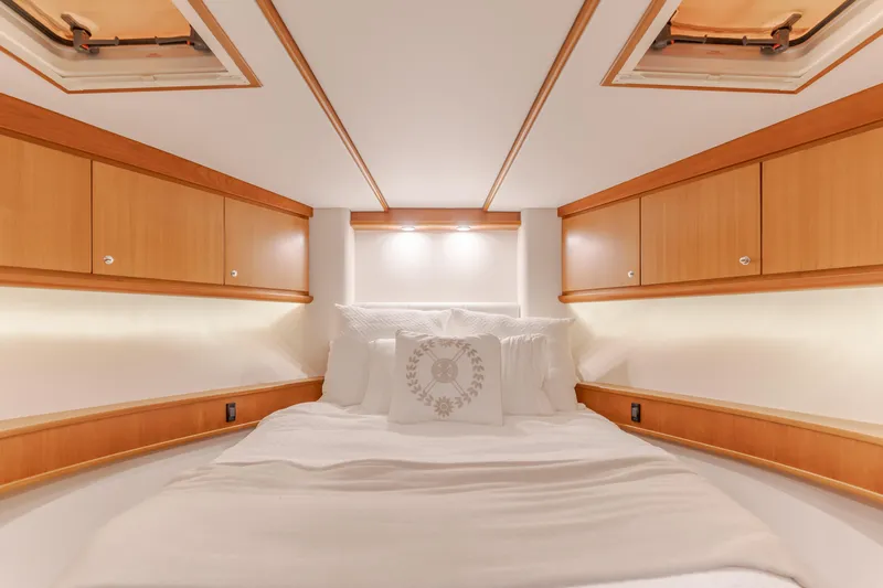 Yacht Photos Pics Luxurious cabin interior of 2006 West Bay 64 yacht with cozy bedding and wooden cabinetry.