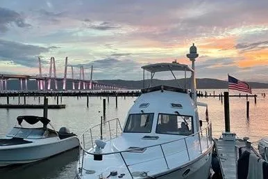  Yacht Photos Pics 2007 Island Pilot 395 yacht docked at sunset near a bridge, with an American flag.