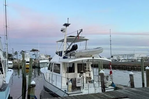  Yacht Photos Pics 2007 Island Pilot 395 docked at marina during sunset, featuring upper deck and dinghy.