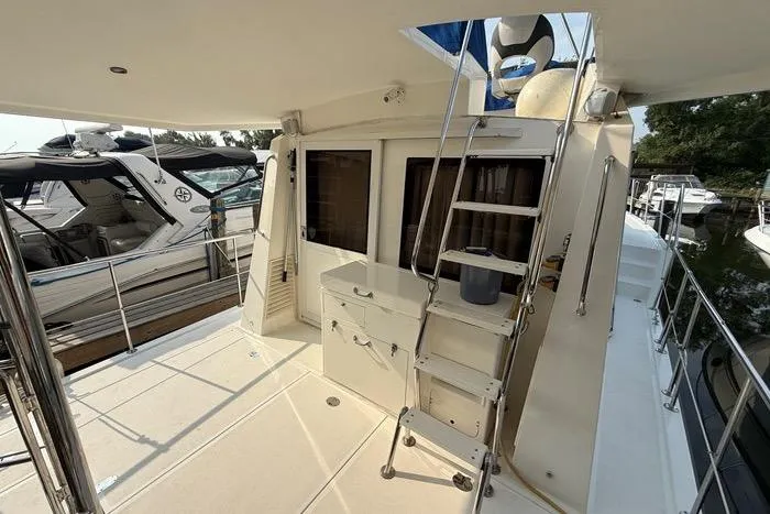  Yacht Photos Pics 2007 Island Pilot 395 yacht deck with ladder and storage, docked beside other boats.