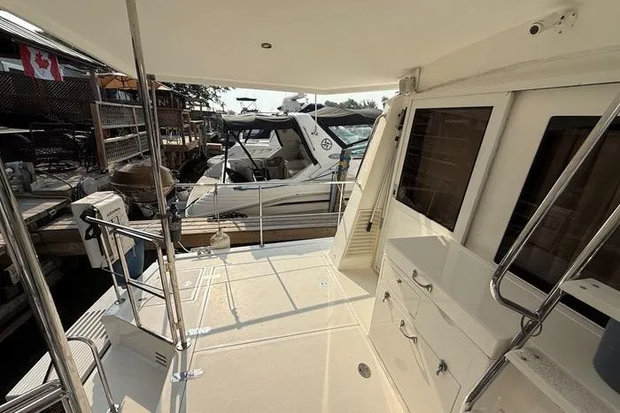 Yacht Photos Pics 2007 Island Pilot 395 yacht deck with railing, docked near other boats, Canadian flag visible.