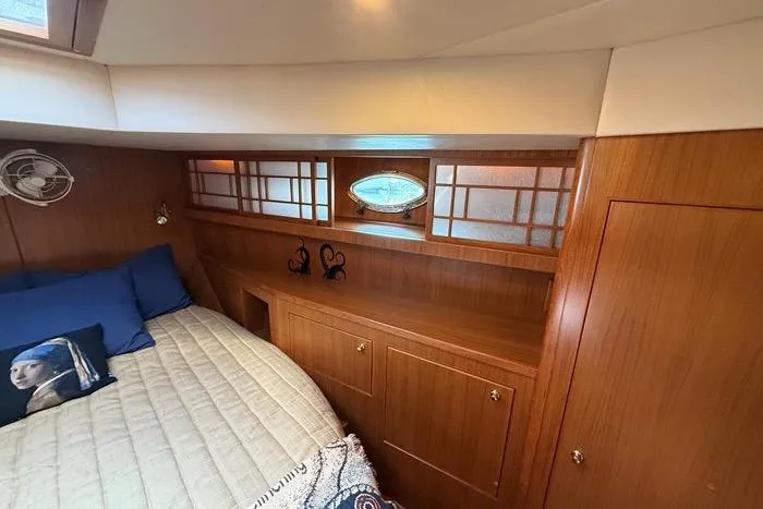  Yacht Photos Pics Luxurious 2007 Island Pilot 395 cabin interior with wood paneling and cozy bedding.
