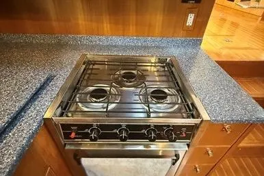  Yacht Photos Pics 2007 Island Pilot 395 yacht kitchen with a three-burner stove and blue speckled countertops.