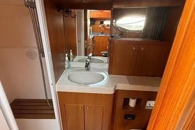  Yacht Photos Pics 2007 Island Pilot 395 bathroom with wooden cabinetry, sink, and shower area.
