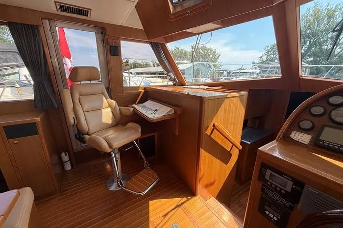  Yacht Photos Pics 2007 Island Pilot 395 yacht interior with helm, leather chair, and navigation equipment.