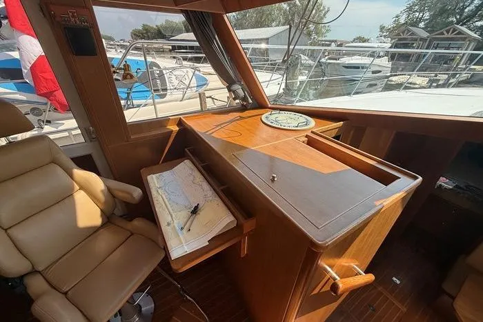  Yacht Photos Pics 2007 Island Pilot 395 helm with navigation chart, compass, and comfortable seating.