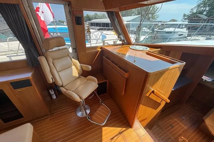  Yacht Photos Pics Interior of 2007 Island Pilot 395 yacht with captain's chair and wooden helm station.