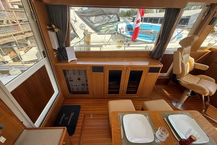  Yacht Photos Pics Luxurious interior of 2007 Island Pilot 395 yacht with dining area and helm station.