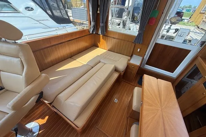  Yacht Photos Pics Interior of 2007 Island Pilot 395 yacht with beige leather seating and wooden accents.