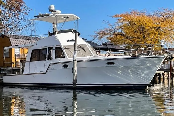  Yacht Photos Pics 2007 Island Pilot 395 boat docked by autumn trees and waterfront homes.