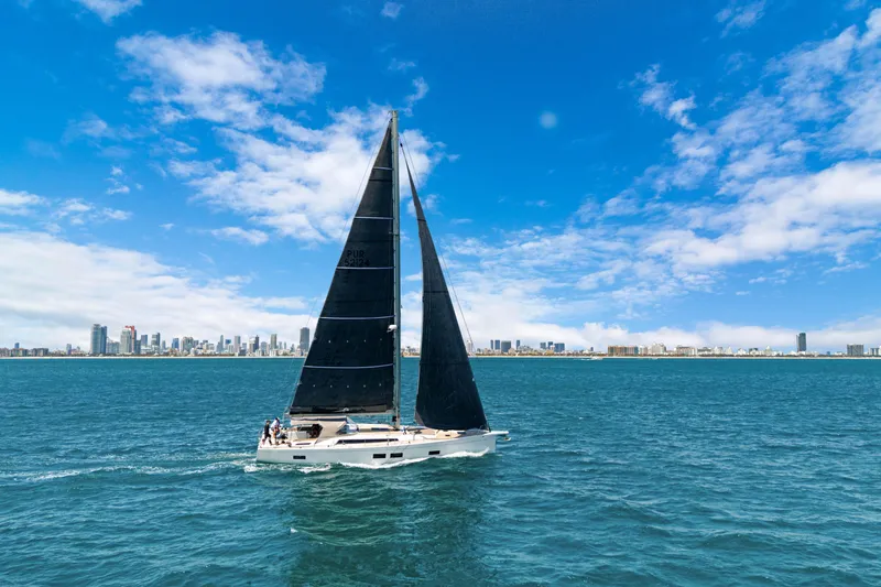 Estela Yacht Photos Pics Grand Soleil 52 Long Cruise 2017 sailing on blue ocean with city skyline in background.