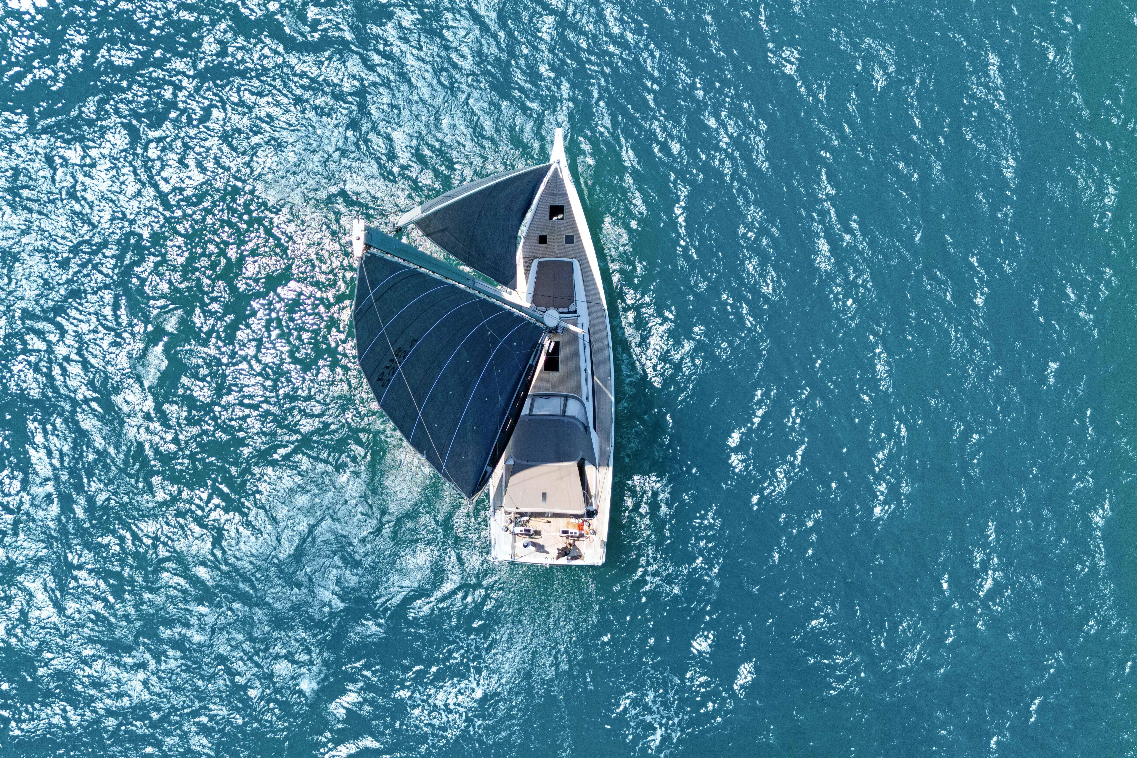 Estela Yacht Photos Pics Aerial view of 2017 Grand Soleil 52 Long Cruise sailing on blue ocean waters.