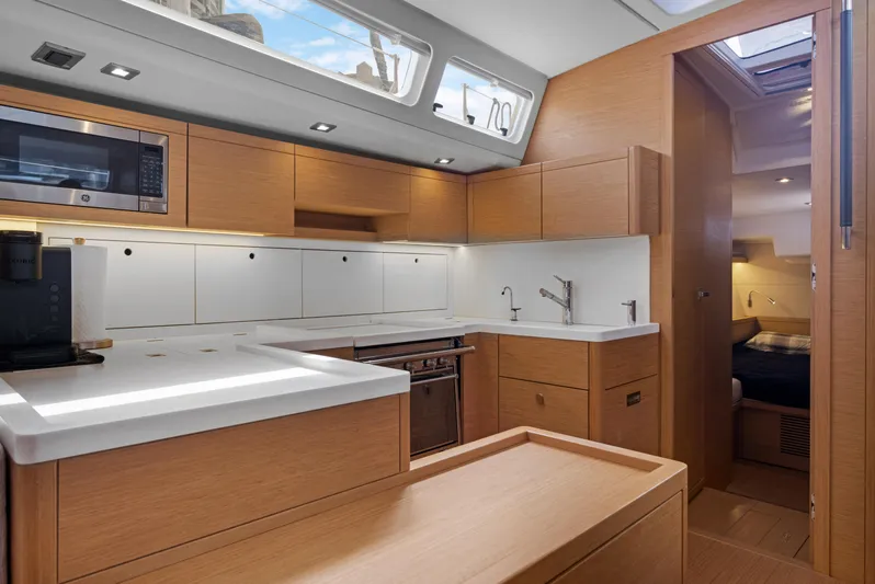 Estela Yacht Photos Pics Modern kitchen interior of 2017 Grand Soleil 52 Long Cruise yacht, featuring sleek wood cabinetry.