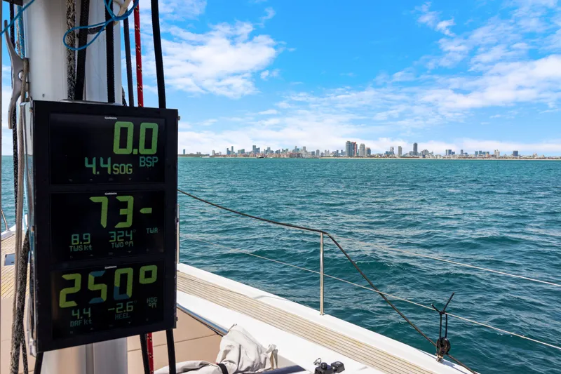 Estela Yacht Photos Pics Grand Soleil 52 Long Cruise 2017 sailing with city skyline in background, digital display visible.