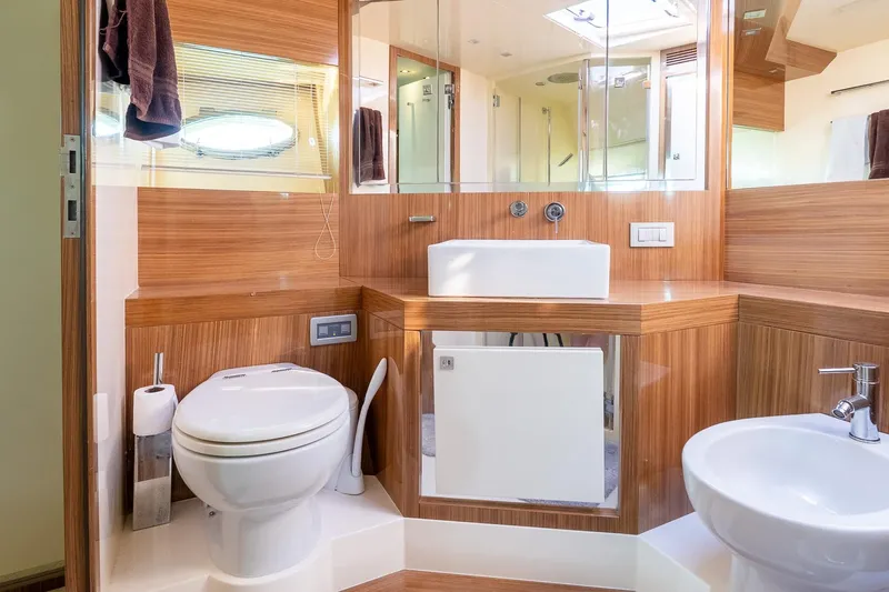 Balliamo Yacht Photos Pics Luxurious bathroom in 2011 Uniesse 55S yacht with modern fixtures and wood paneling.