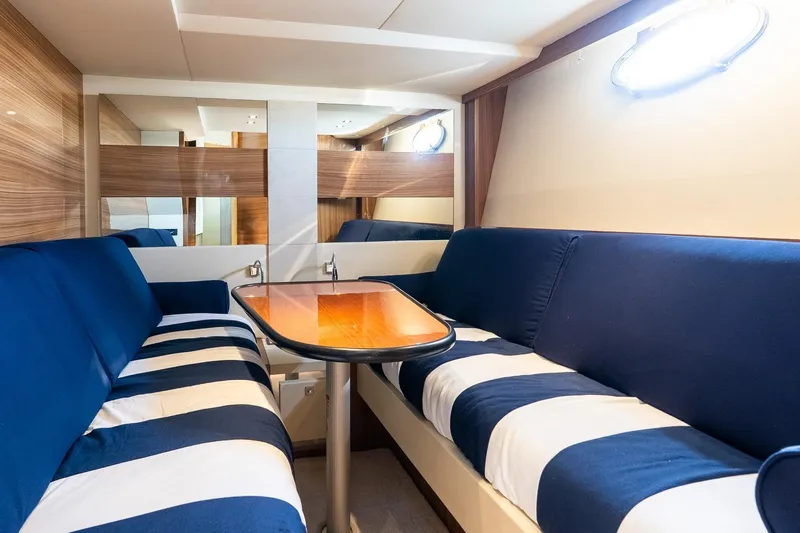 Balliamo Yacht Photos Pics Luxurious interior of 2011 Uniesse 55S yacht with striped seating and wooden table.